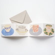Load image into Gallery viewer, A card that unfolds to reveal four beautifully illustrated cups and saucers.
