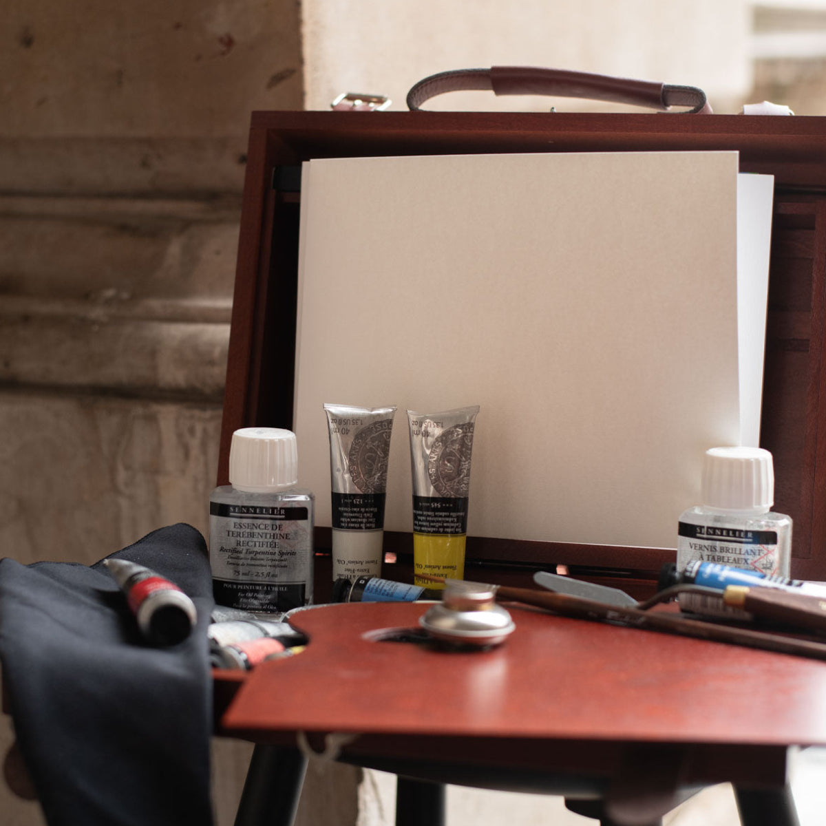 Wooden art box with art materials and leather stripes