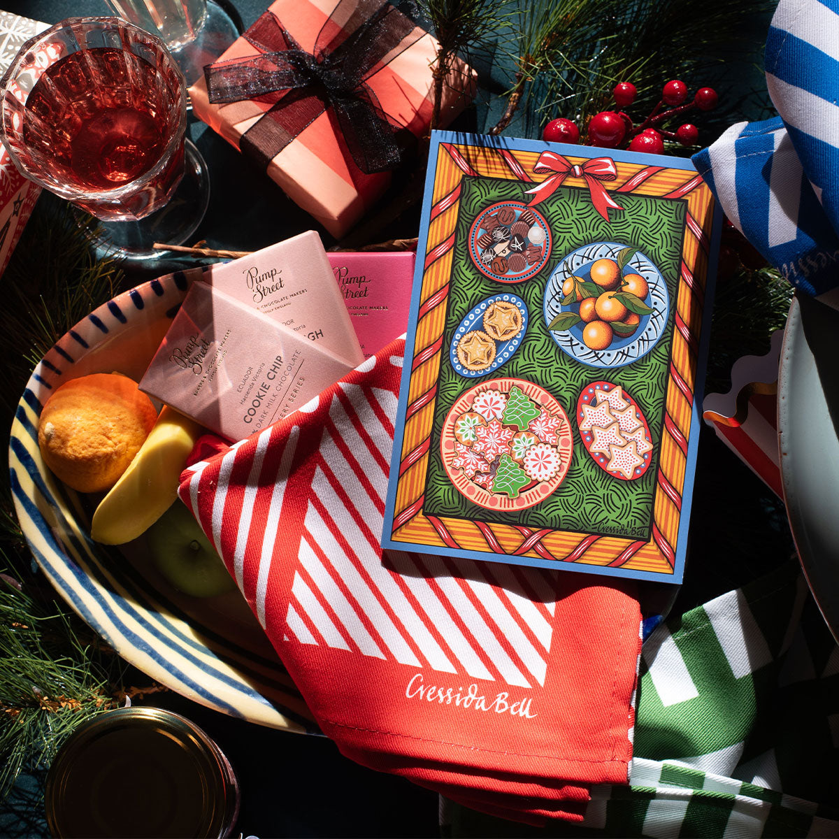 Colorful holiday-themed napkin with festive design on a table with Christmas decorations.