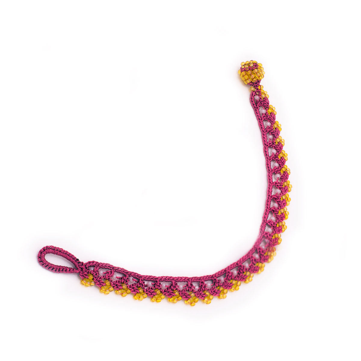 Bracelet with pink and yellow beads on a white background